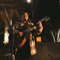 young woman playing the guitar and singing