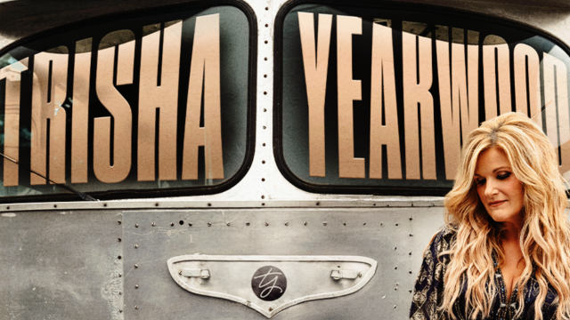 Blonde woman standing in front of silver bus that says Trisha Yearwood