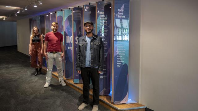 Local Artists Safwat Saleem, Ben Lewis and Chelsea Hickok stand in front of the interactive donor wall at the CCA