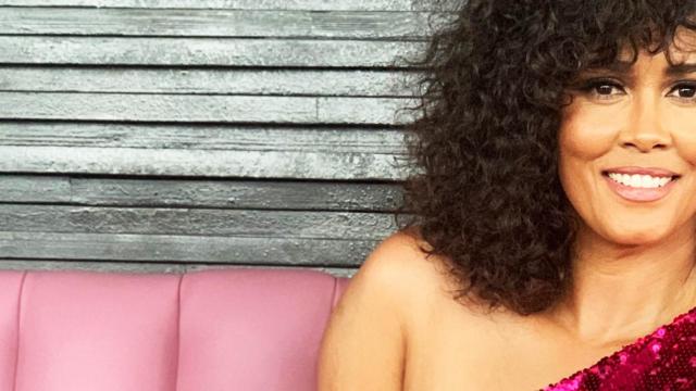 Belinda Davids, singer in The Greatest Love of All, sits on a pink banquet wearing a sparkling magenta dress.
