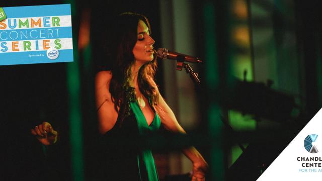 Kim Weston, wearing a green dress, sings into a microphone.
