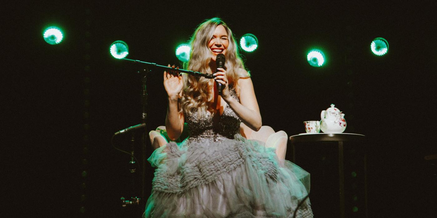 Joss Stone sitting on stage singing into microphone