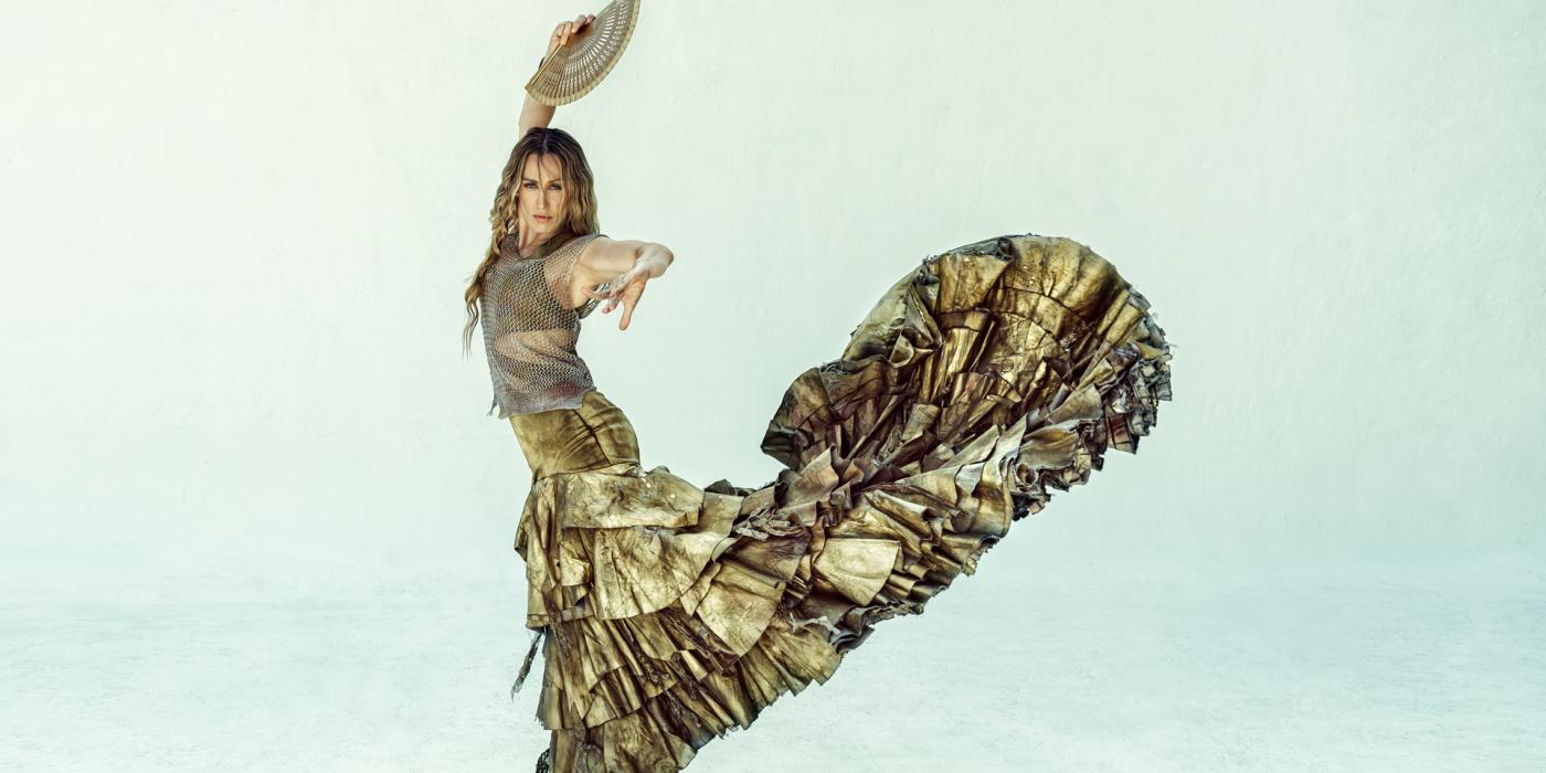 Woman flamenco dancer wearing gold dress.