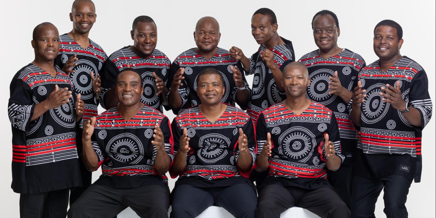Group of African men wearing black shirts with red designs.