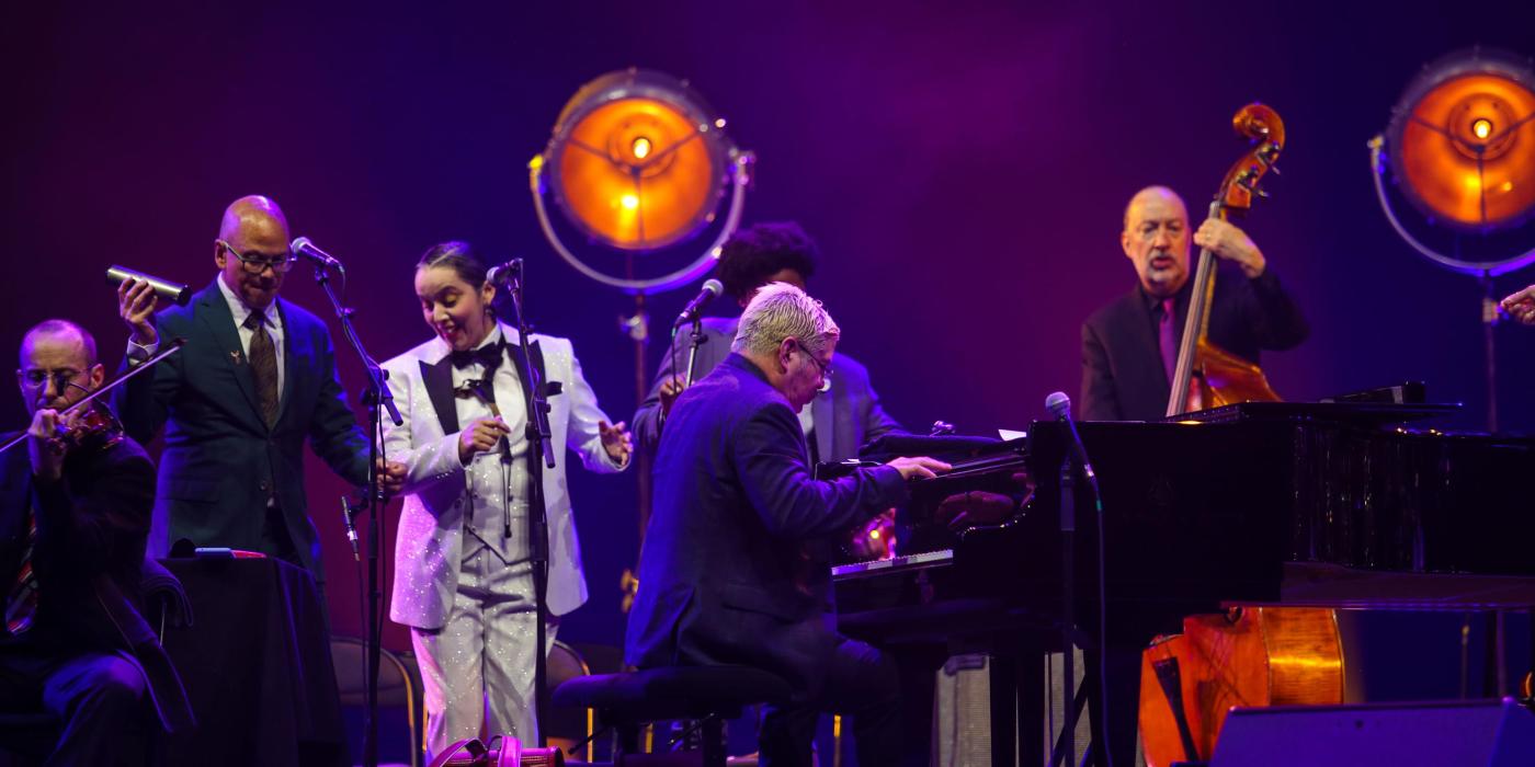 Band on stage with purple lighting and glow lights
