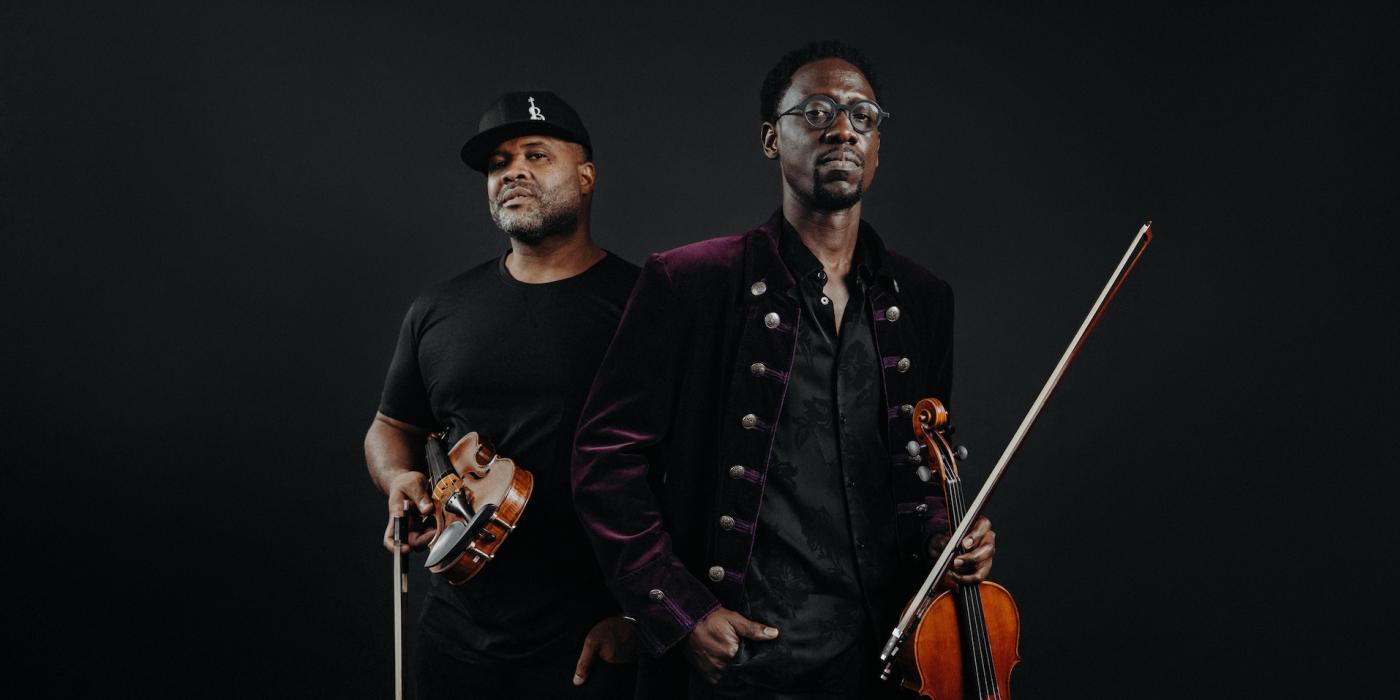 the members of Black Violin holding violins. 