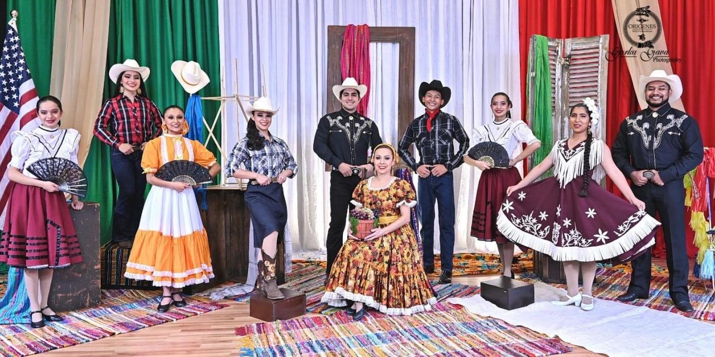 Seven women and three men pose in colorful costumes traditional for the northern region of Mexico, including cowboy hats and ribbon-trimmed skirts
