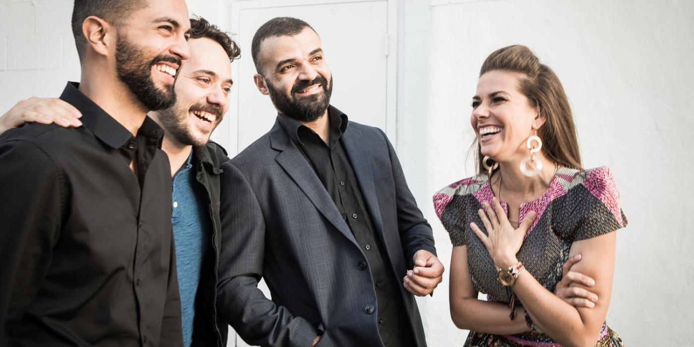 Caro Pierotto laughs with three band members.
