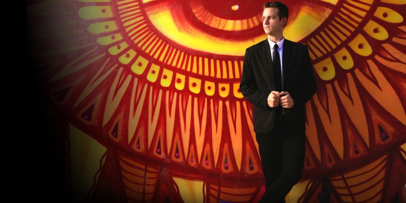 Eric Giliam in front of an intricate mural