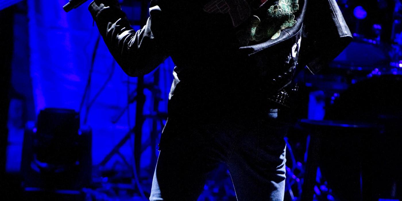 Performing on stage with black leather jacket with red rose on back