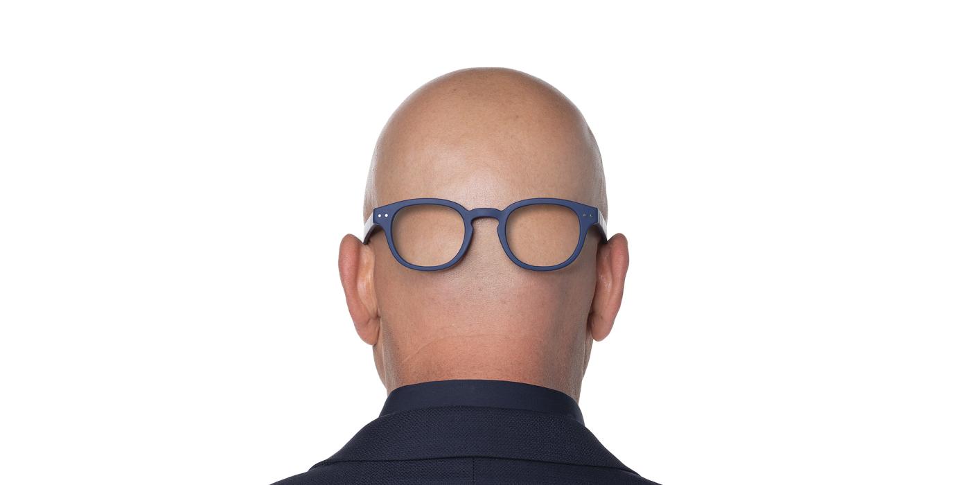 Photo of the back of Howie Mandel's bald  head with eye glasses put on back of the head
