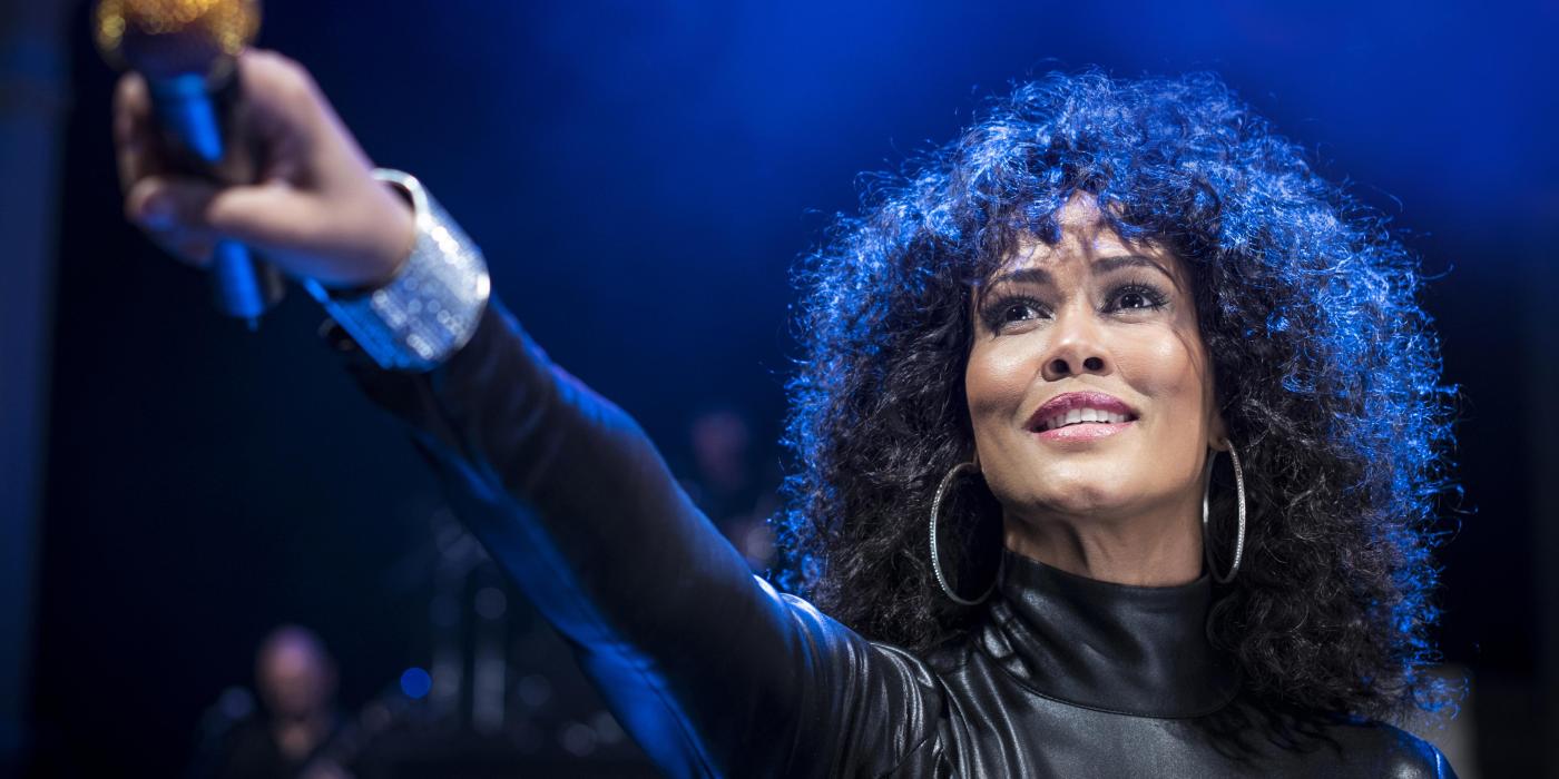 Belinda Davids holding a microphone out to the audience