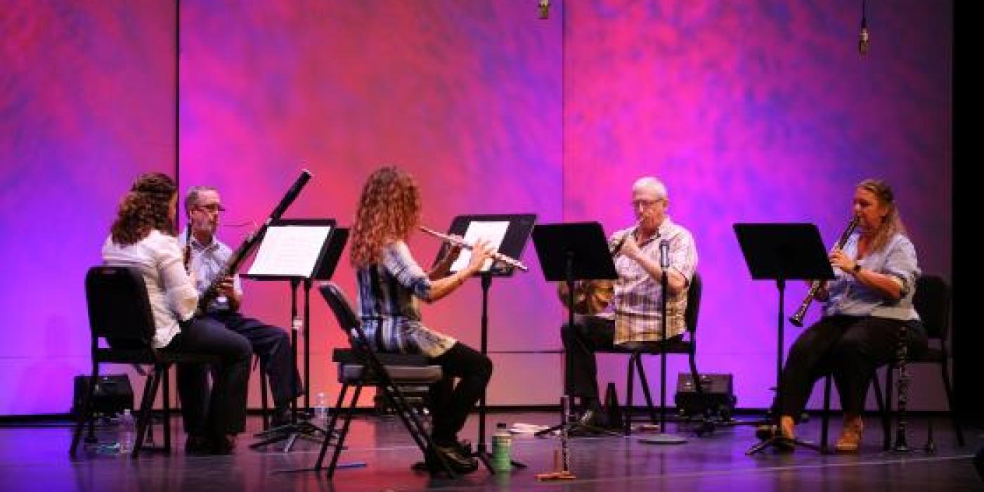 Chandler Symphony Orchestra's Wind Quintet performs in front of a pink backdrop.