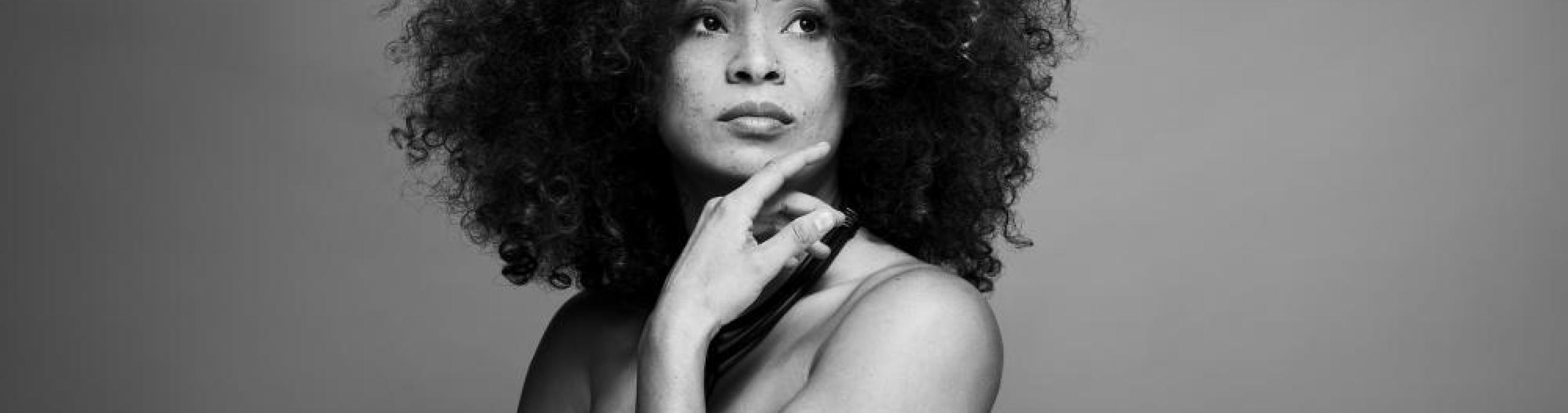 In this black-and-white photo, singer Kandace Springs rests her chin on her hand and looks off into the distance.