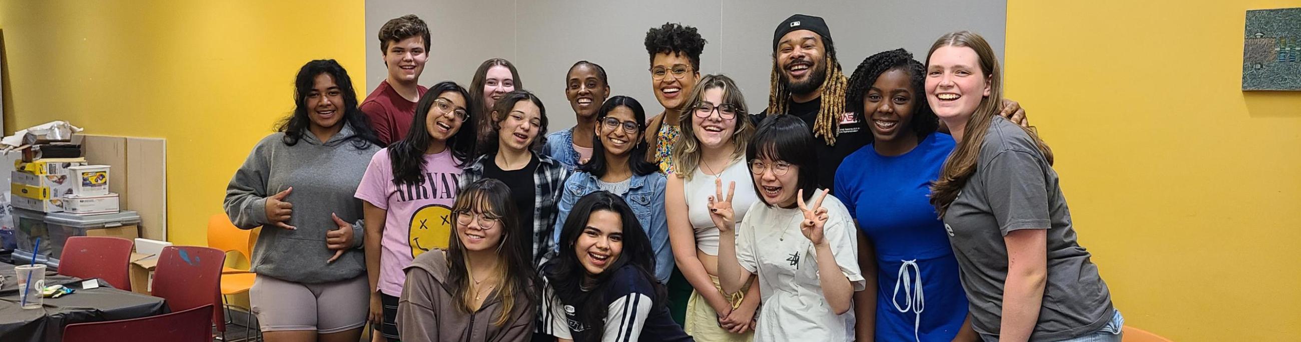 A group of 12 diverse teenagers pose with three adult mentors