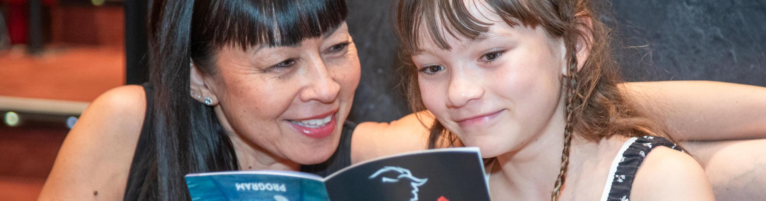 Adult and child smiling at Beauty and the Beast program