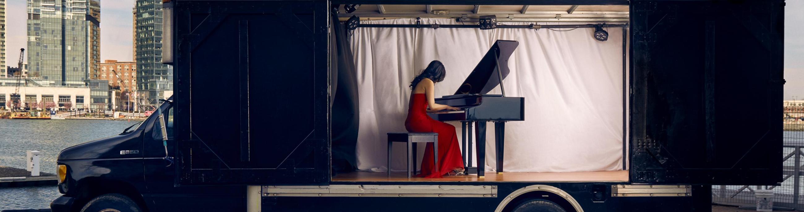 Susan Zhang playing the piano inside the Concert Truck