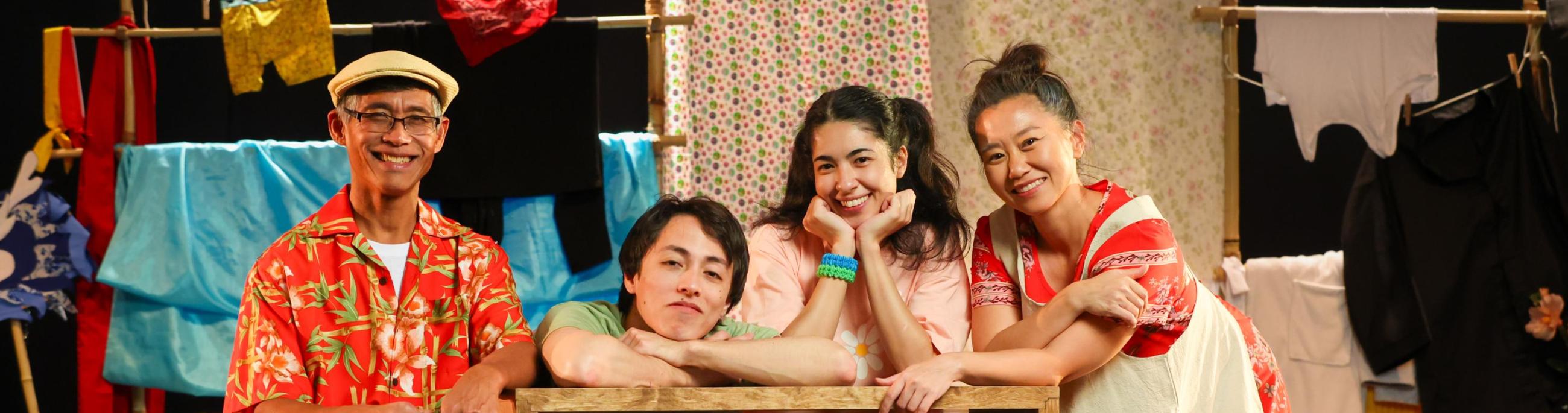 Family on stage surrounded by colorful fabric