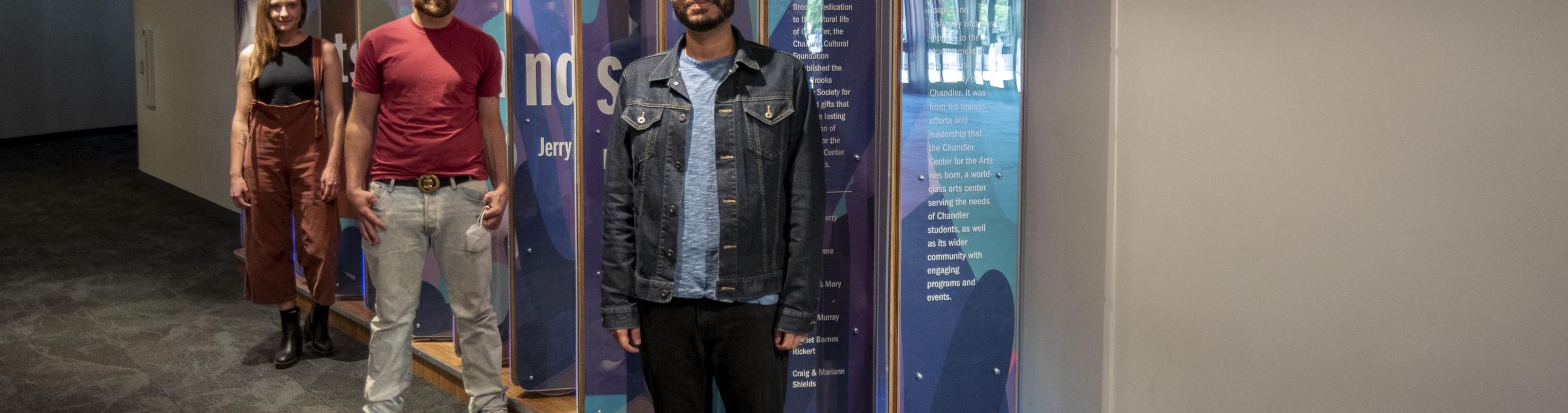 Local Artists Safwat Saleem, Ben Lewis and Chelsea Hickok stand in front of the interactive donor wall at the CCA