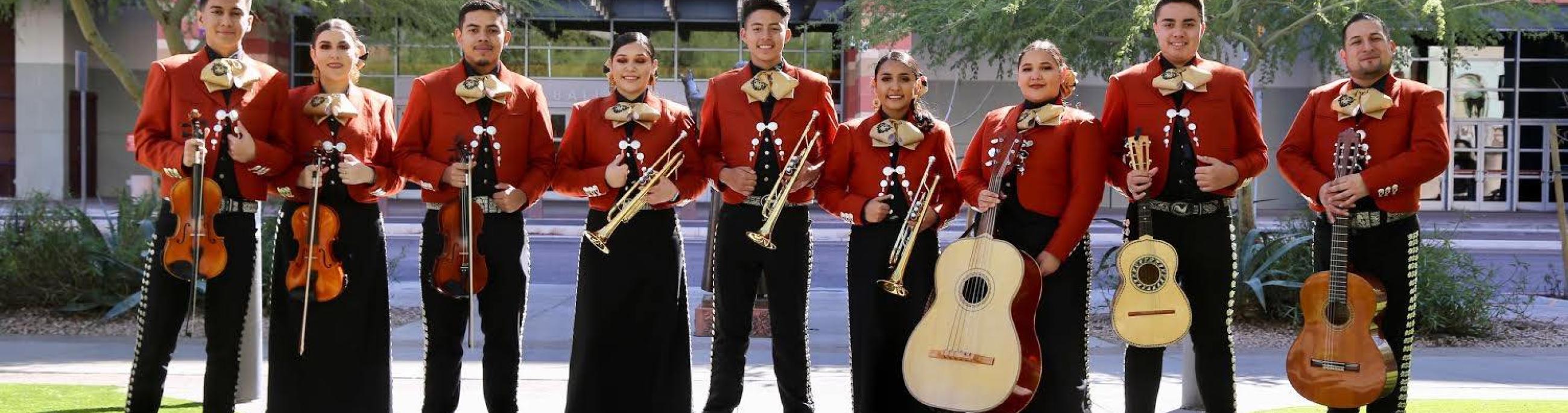 Mariachi Corazon del Valle pose outdoors with their instruments.