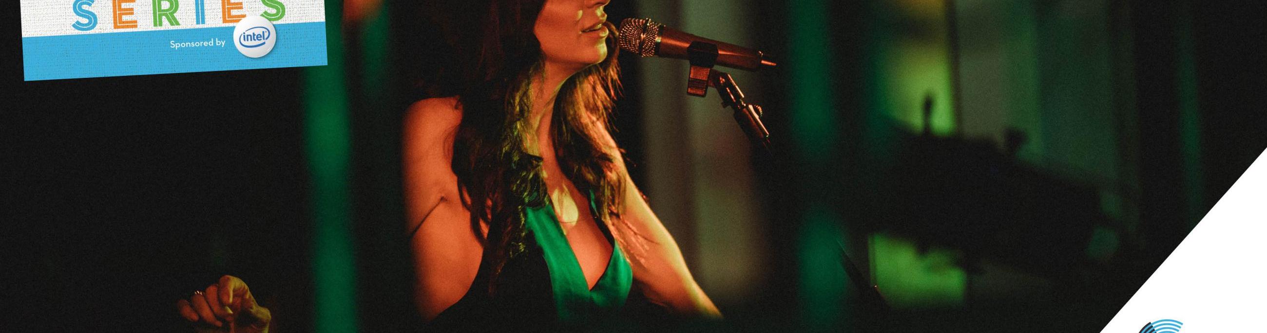 Kim Weston, wearing a green dress, sings into a microphone.