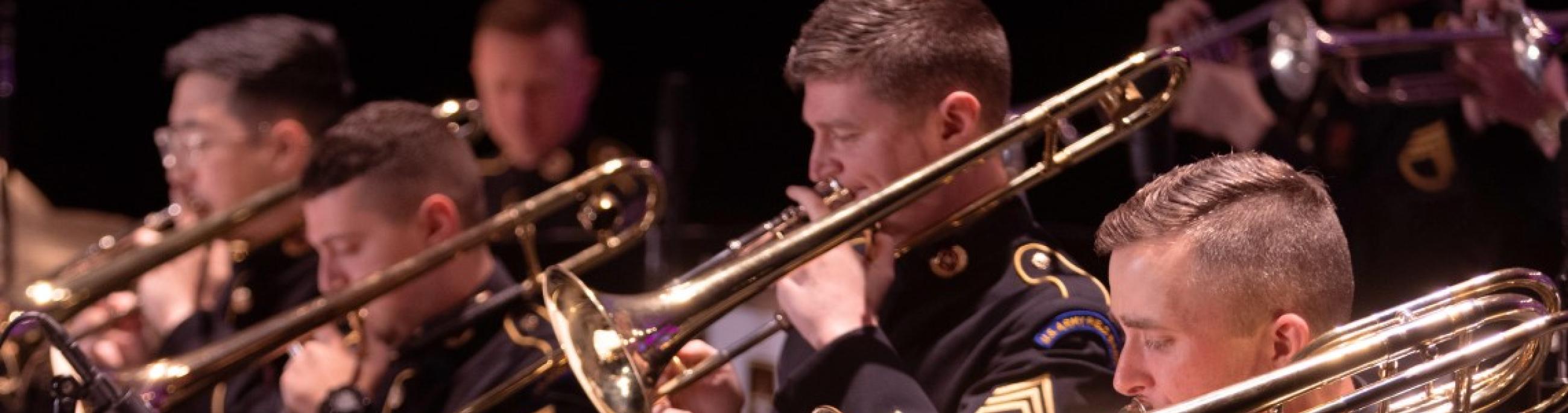 men playing trombones wearing dark uniforms