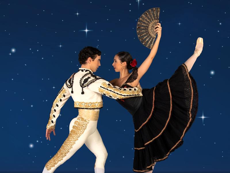a man and woman dance against a night sky