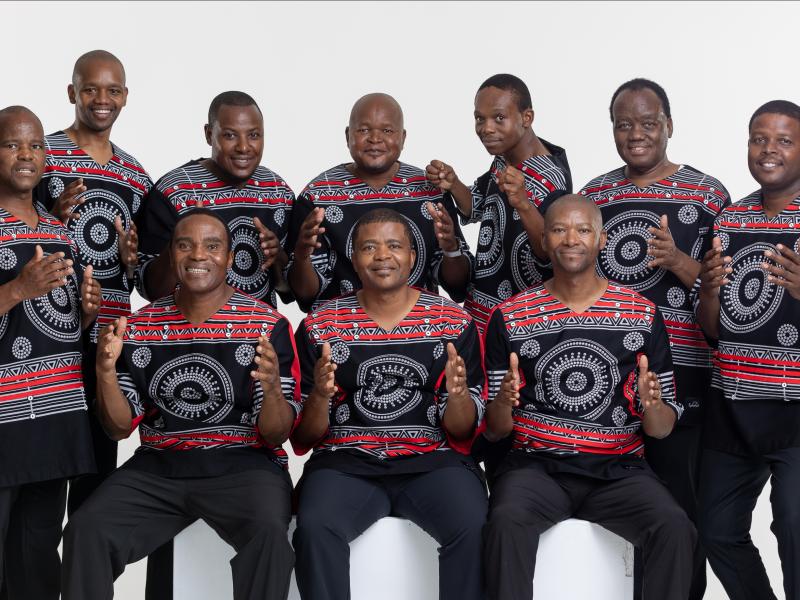 Group of African men wearing black shirts with red designs.