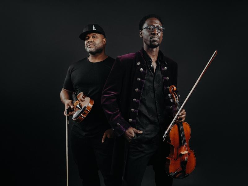the members of Black Violin holding violins. 