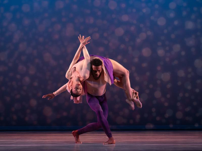 dancer stretching her back while on the shoulders of another dancer