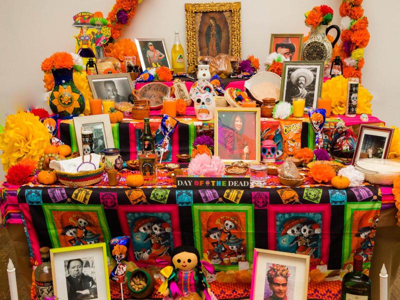 Community altar laden with photos and treats.