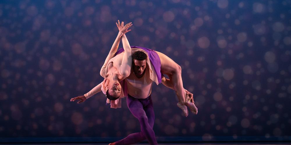 dancer stretching her back while on the shoulders of another dancer