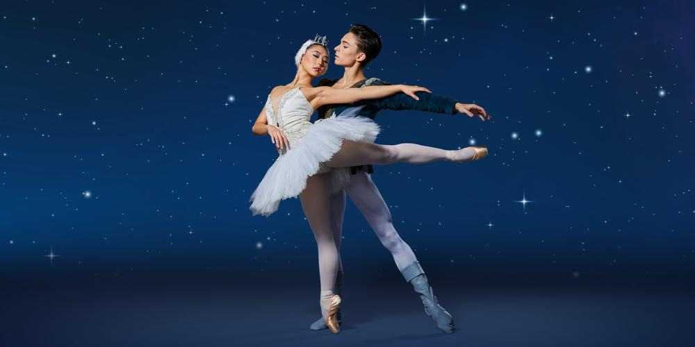 two ballerinas embracing against the night sky