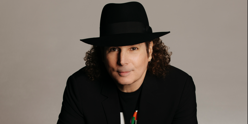 Boney James in a black hat and jacket with his saxophone in front of him