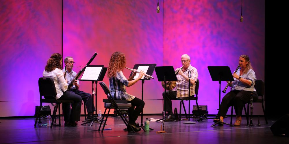 Chandler Symphony Orchestra's Wind Quintet performs in front of a pink backdrop.