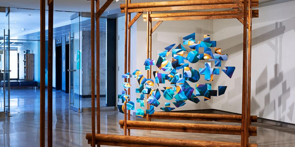 large, square, wooden structure with blue material hanging in small amounts in the center of the squares.