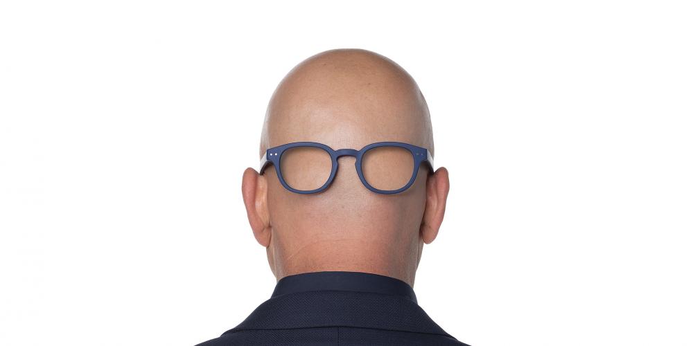 Photo of the back of Howie Mandel's bald  head with eye glasses put on back of the head