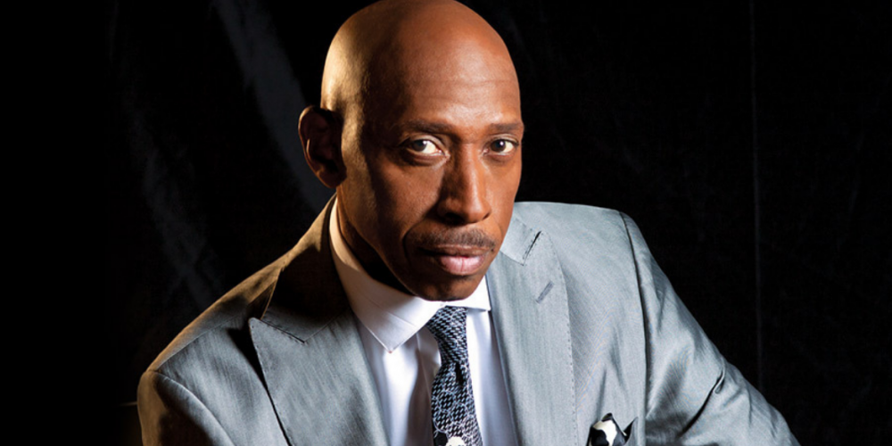 Jeffrey Osborne wearing a silver suit and tie