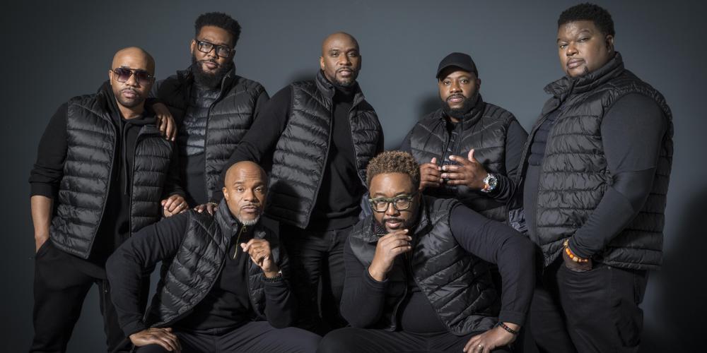 An image of the band Naturally 7 - seven men all dressed in black