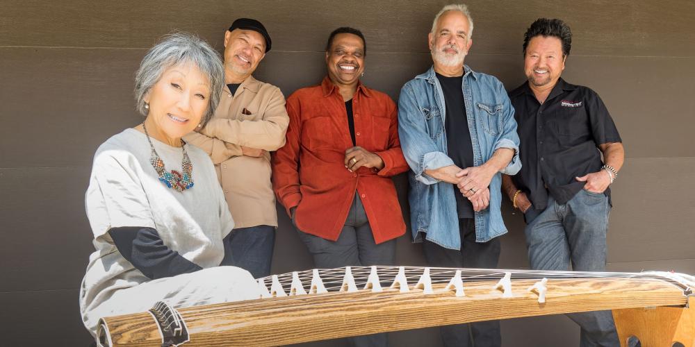 An image of the band Hiroshima - 4 men and one woman in front of a Japanese string instrument