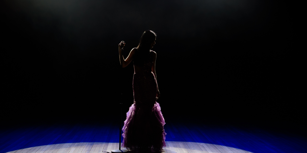 Female singer on stage with a spotlight