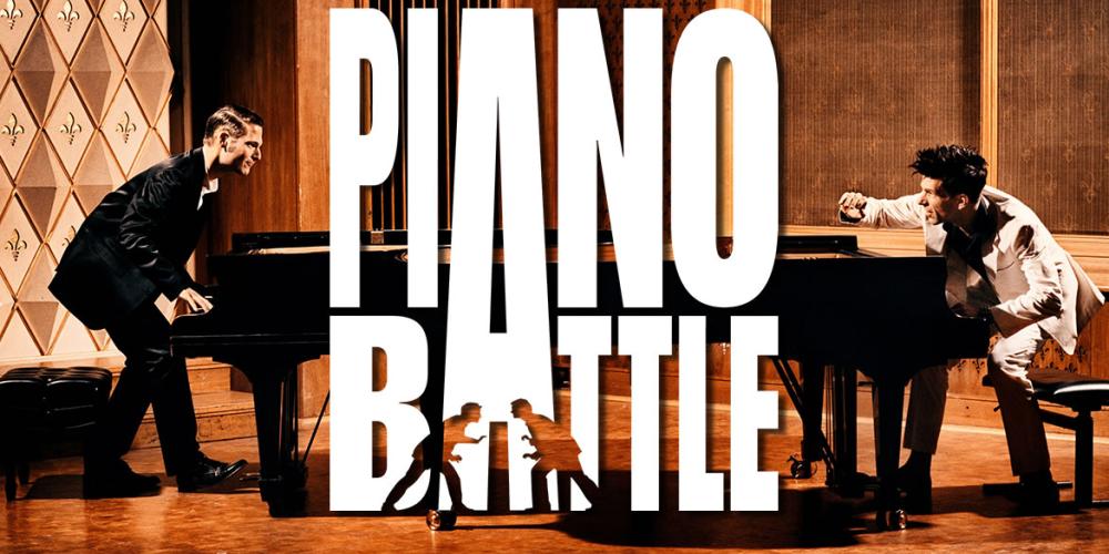 Photograph of Adreas and Paul on stage behind their pianos with the words "Piano Battle" in bold white text.