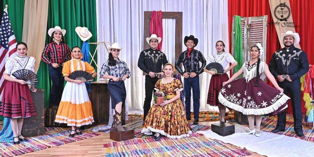 Seven women and three men pose in colorful costumes traditional for the northern region of Mexico, including cowboy hats and ribbon-trimmed skirts
