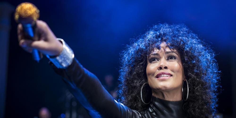 Belinda Davids holding a microphone out to the audience