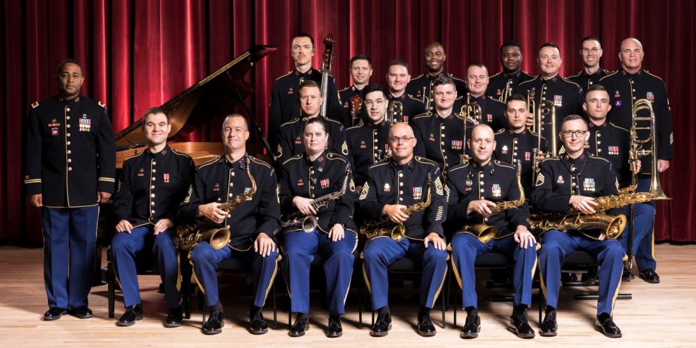 group of men in uniforms surrounding a piano and in front of a red curtain