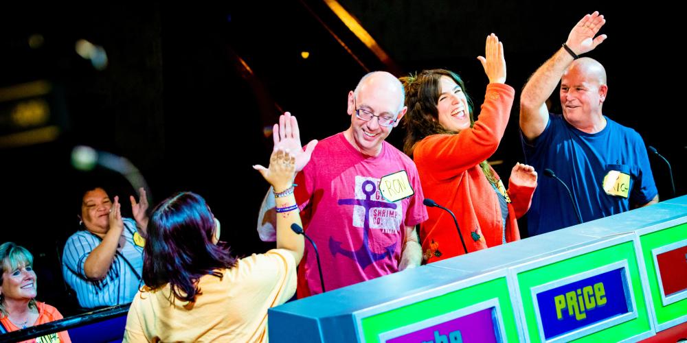 four contestants cheering and giving high fives to each other