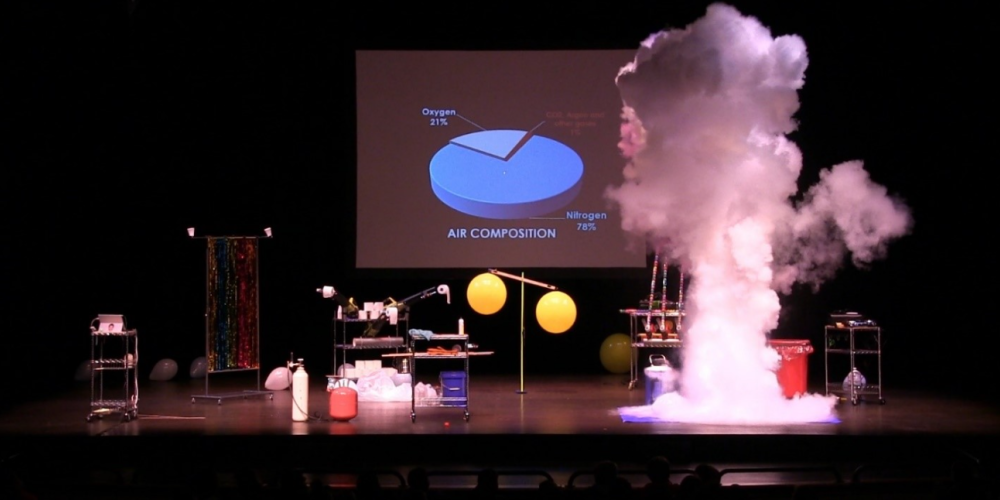pie char of air composition on screen with smoke and other science related materials on stage
