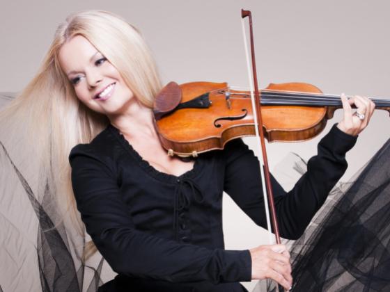 Mairead Nesbitt, wearing a black dress, plays the fiddle 