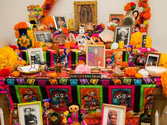 Community altar laden with photos and treats.
