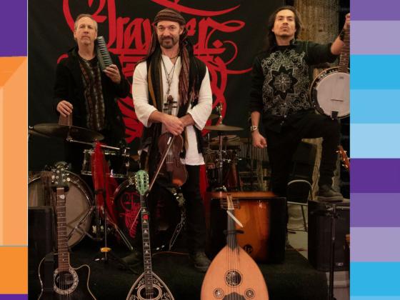 Three men look at the camera, holding string instruments and string instruments displayed in front of them